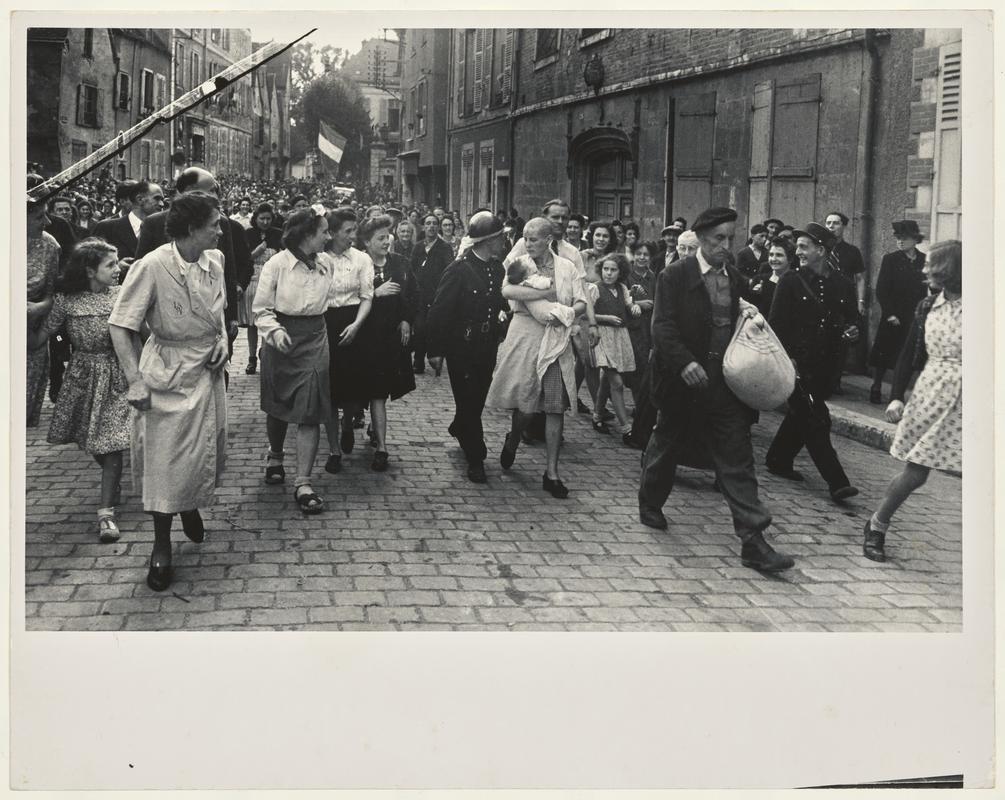 French woman, who had a baby fathered by a German soldier, being marched through the streets after