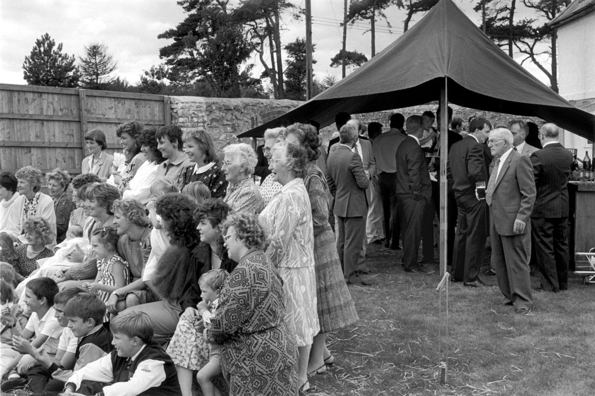 GB. WALES. Castleton. Family gathering for a photograph of the women and children. Men in the beer tent. 1989.