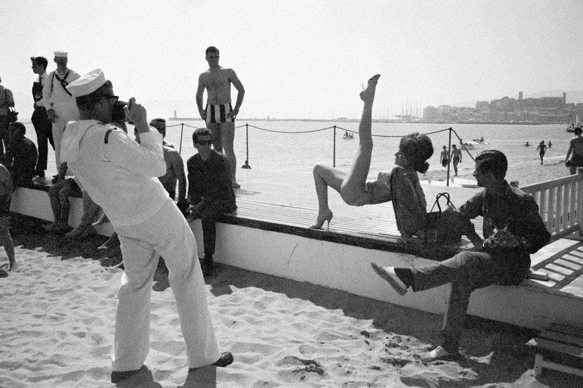 FRANCE. Cannes. Minor star poses on the beach at the Cannes Film Festival. An American ship had arrived in the bay and the sailors were on shore leave. 1964.