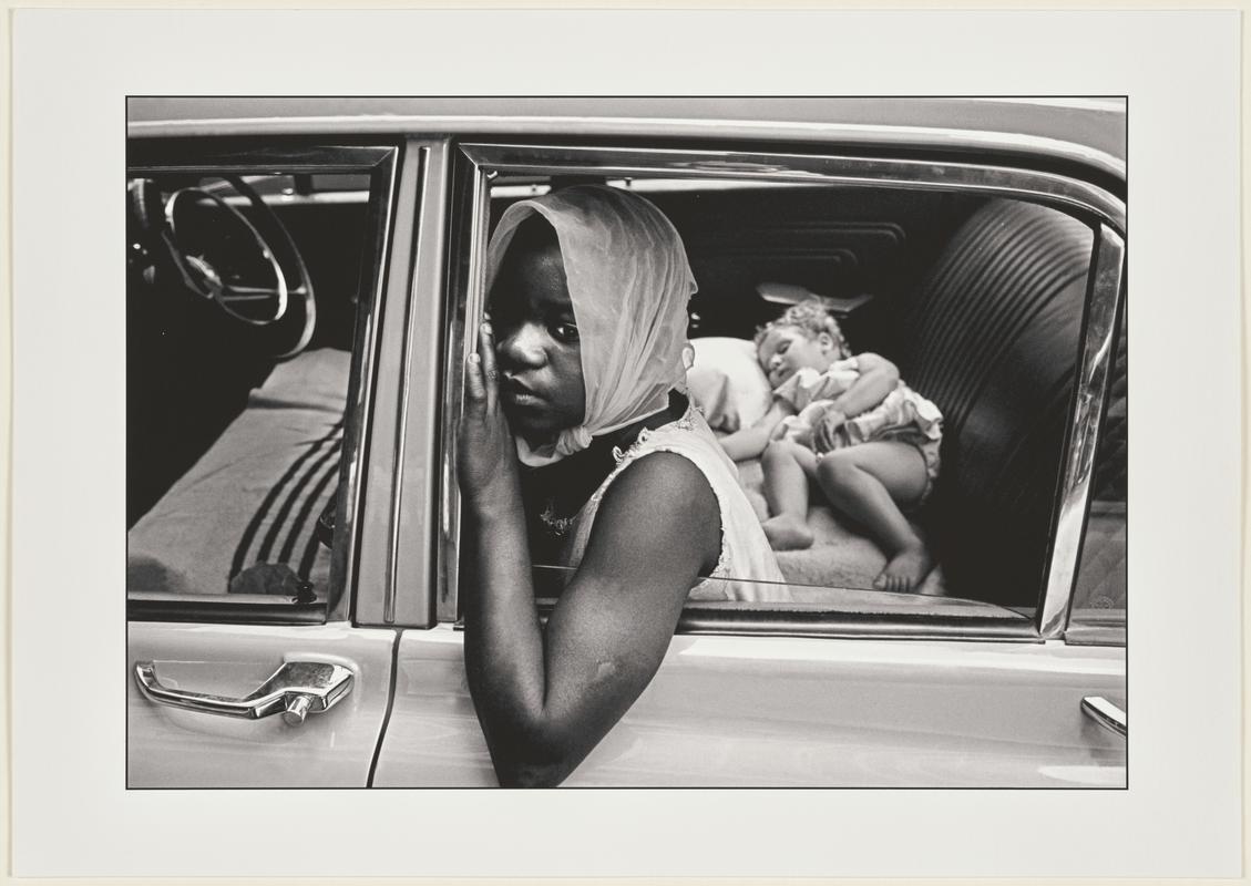 A young black girl, scarcely more than a child herself, looks after a baby girl for a white family, South Africa