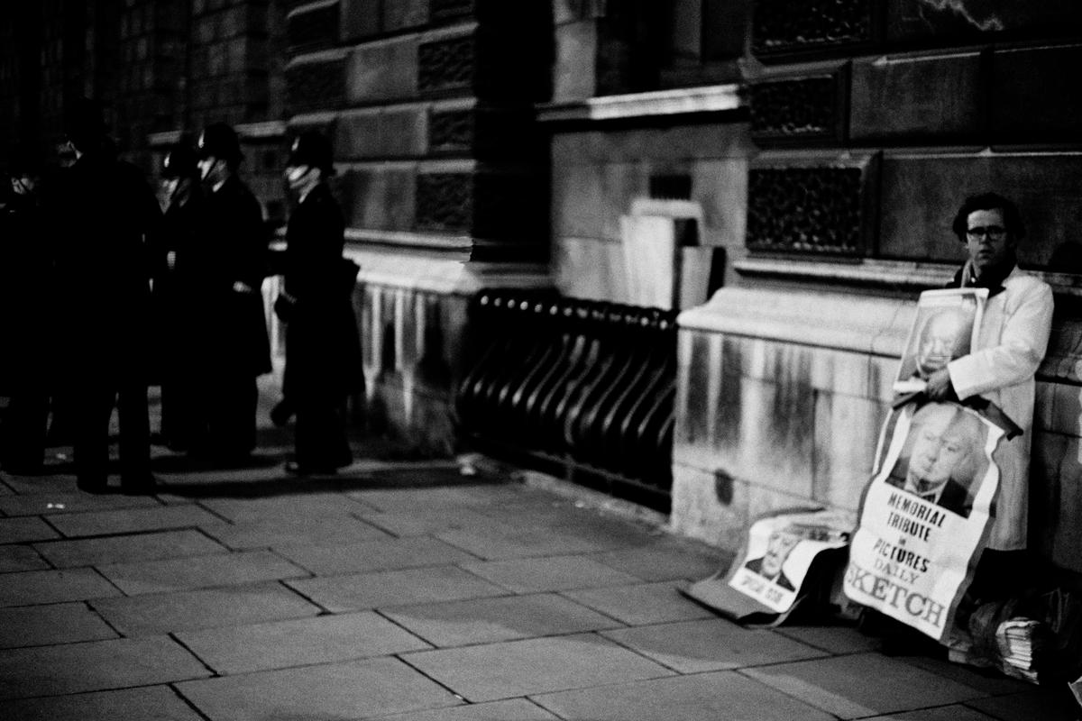 GB. ENGLAND. London. Winston CHURCHILL funeral. Early morning. Newspaper seller. 3 January 1965.