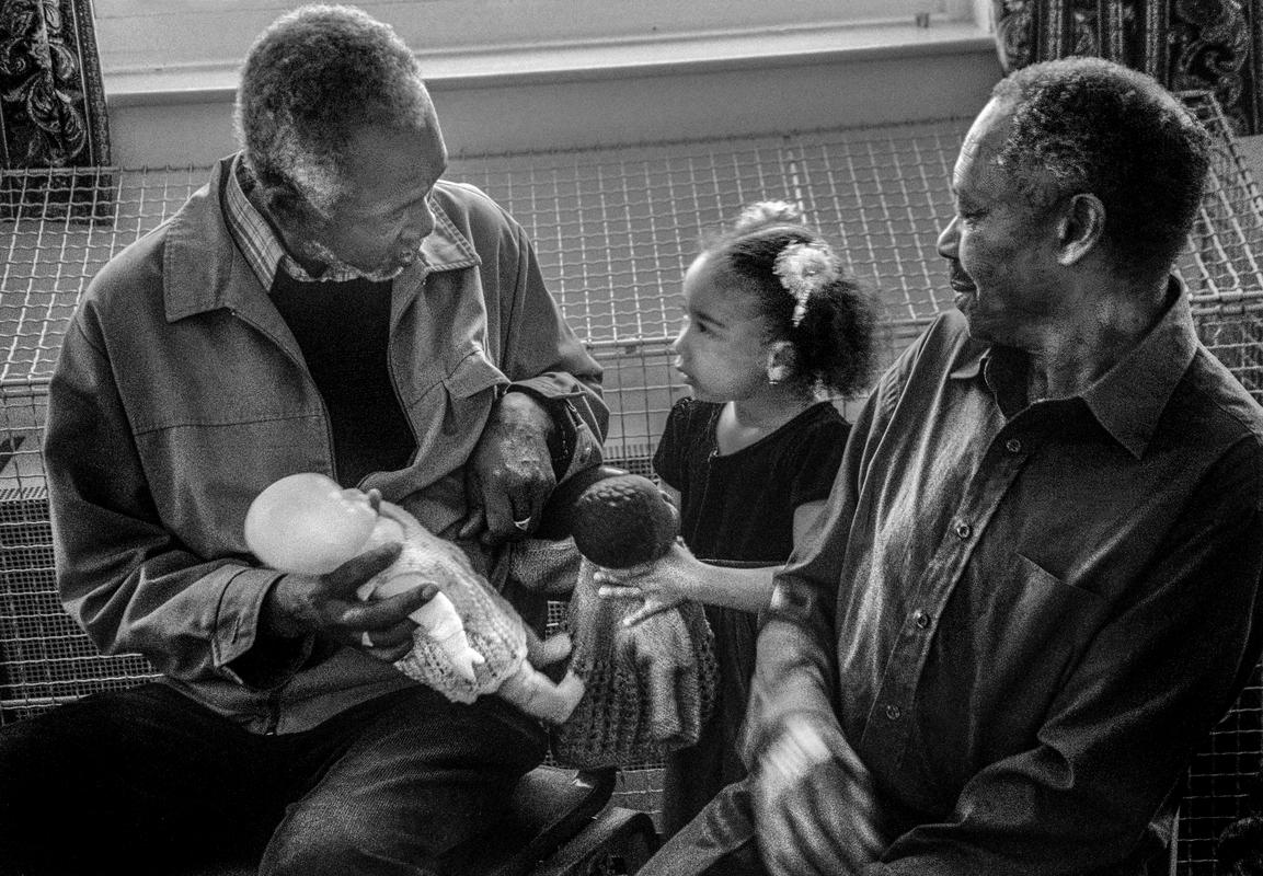 GB. WALES. Cardiff. Butetown - once know as &#039;Tiger Bay&#039;. Carl Alexis and granddaughter in St Paul&#039;s, Loudoun Square. 2003.