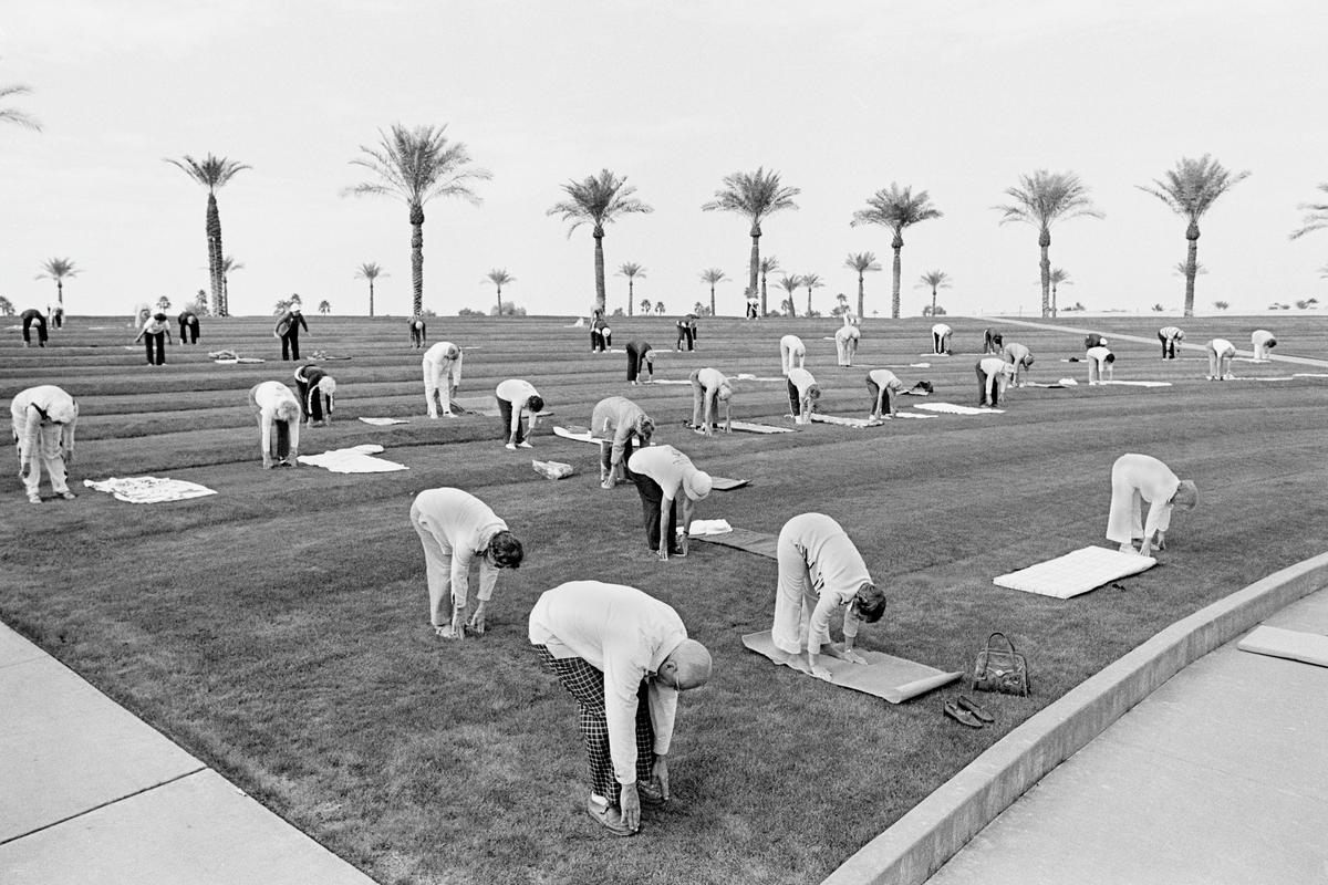 USA. ARIZONA. Sun City  Outdoor group fitness early in the morning in the retirement Sun City.  Ages range from 60 to a 94 year old who had run a 50 secs hundred meters in the Senior Olympics.  The sense of fun and community was very infectious. 1980.