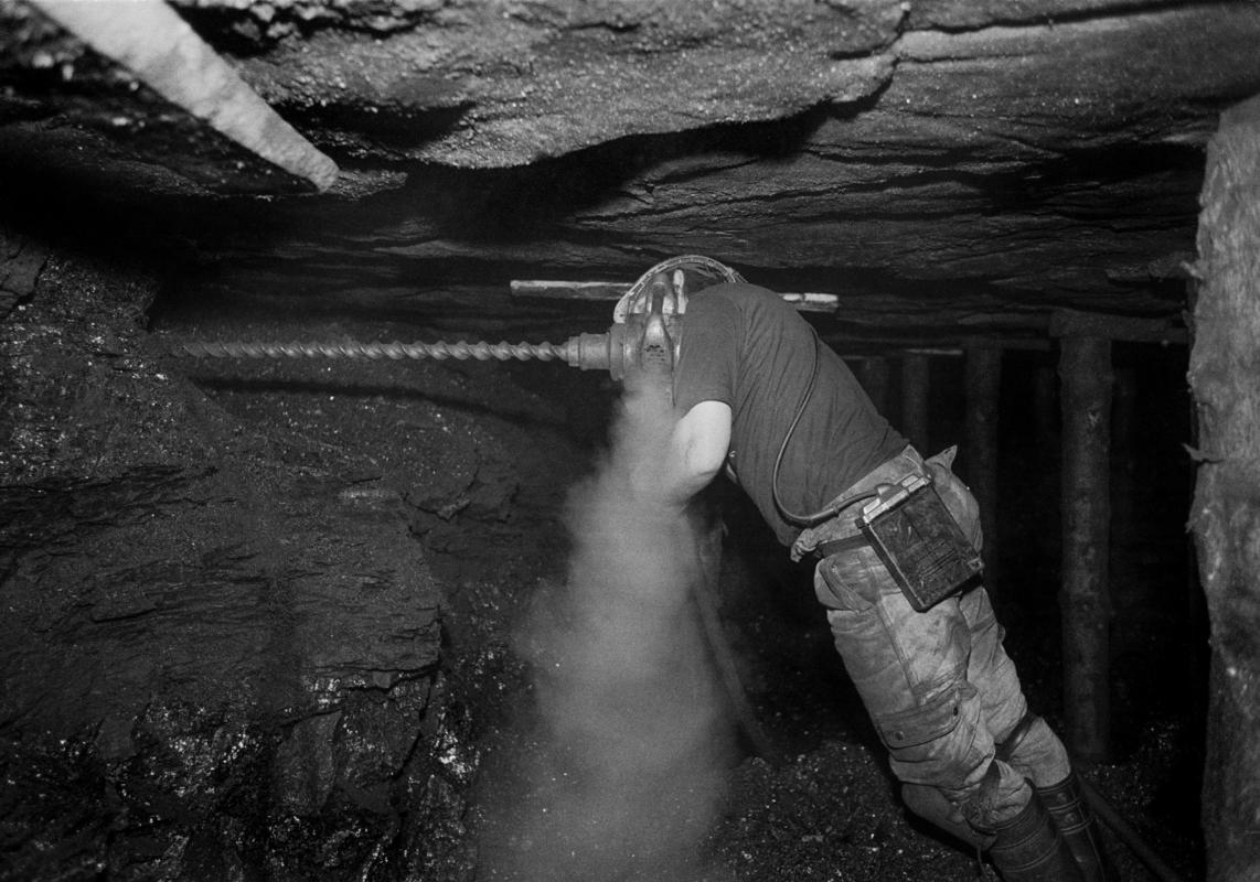 GB. WALES. Neath Valley. Black mountain coal. Miner drilling plug hole for blasting. 1993