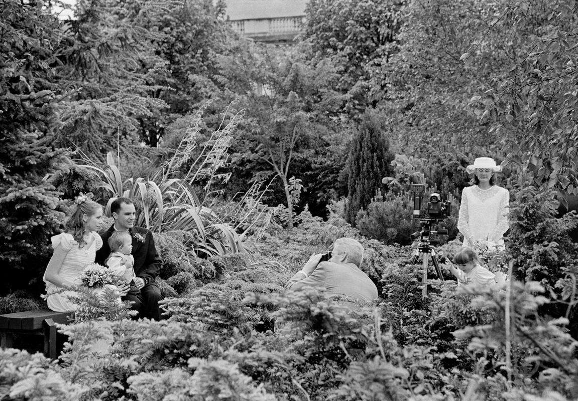 GB. WALES. Cardiff. Wedding photograph in Cathay&#039;s Park in central Cardiff. Slightly sureal as one photograph seemingly gets taken with no photographer. 1997.