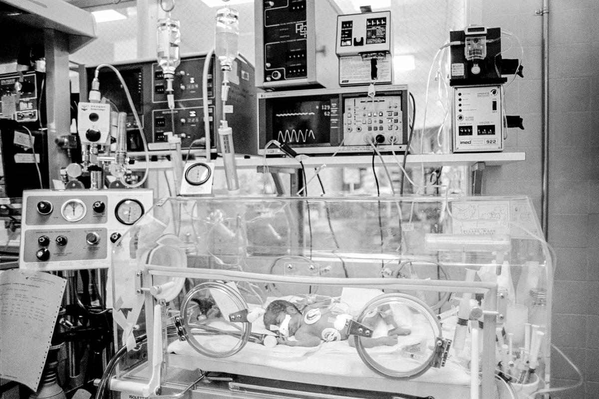 USA. ARIZONA. Phoenix. Preemie Baby unit at St Joseph&#039;s Hospital. I.C.U. Center; Isolette. Top Right; IV Pump. Middle; Cardiac &amp; Respiratory monitor. Left; Respirator. Umbilical catheter in navel. 3 Electrodes for heart &amp; respiratory rate, endotracheal tube in nose. Preemie baby under 2 lb at birth.