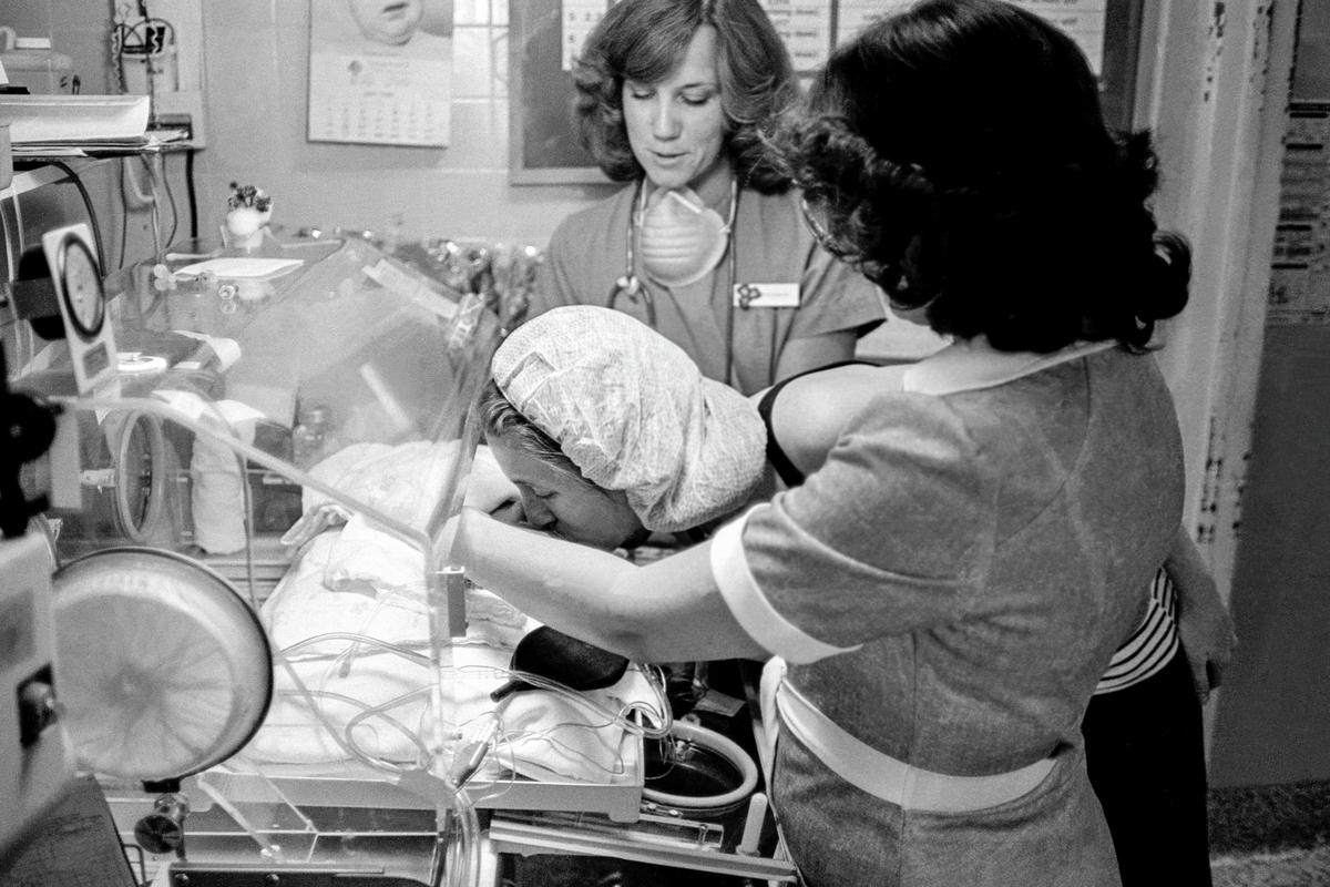 Preemie Baby unit at St Joseph&#039;s Hospital. The mother feels much closer to her daughter after the nurses opened the incubator (I.C.U.) for a kiss. Phoenix, Arizona USA