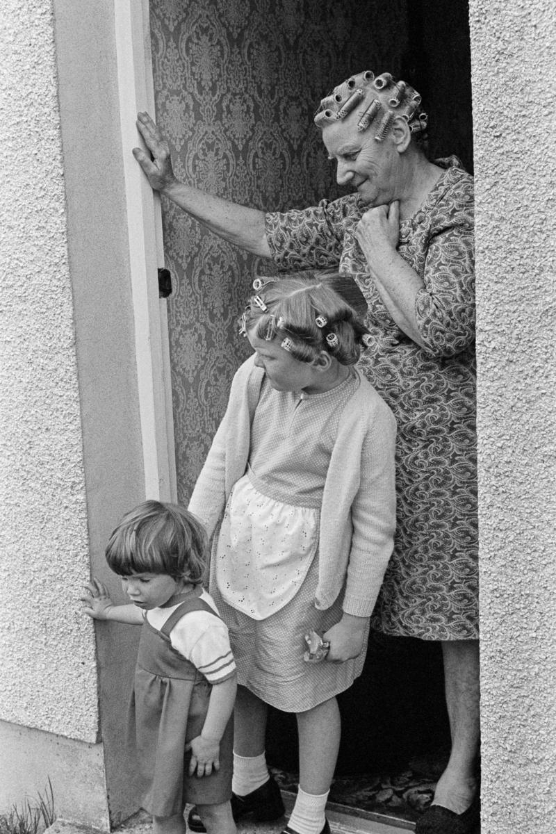 GB. WALES. Ammanford. Family at their front door. 1978.