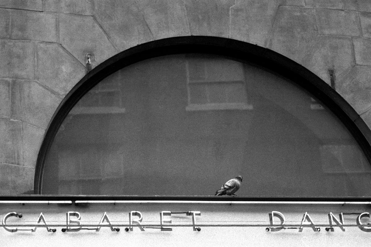 GB. ENGLAND. London. Street scene in Soho in the centre of London. One of the first pictures ever taken by David Hurn, shot on a Kodak folding Retina camera (first camera). 1955.