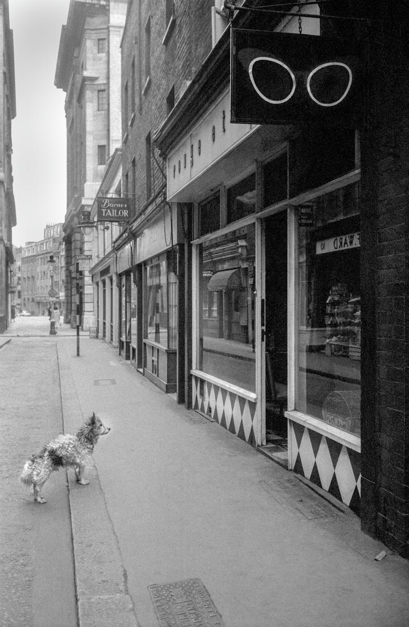 GB. ENGLAND. London. Street scene in Soho in the centre of London. One of the first pictures ever taken by David Hurn, shot on a Kodak folding Retina camera (first camera). 1955.