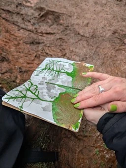 Sketch book open with an draw image of a tree 